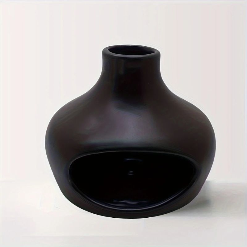 A black ceramic hideout with a rounded, bulbous shape, a narrow top opening, and a large front cutout. The surface is smooth and matte, designed for small animals or decorative use.