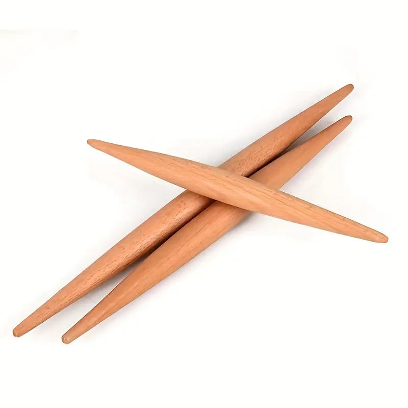Three wooden rolling pins with a tapered design, crossed over each other on a white background.