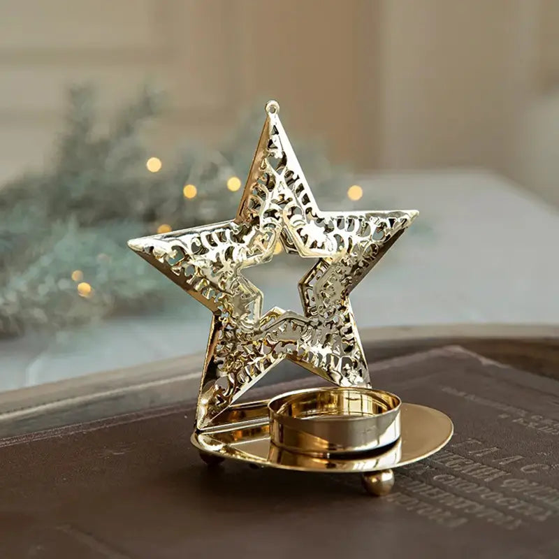 A single golden star-shaped tea light holder sitting on a dark book, without a candle.