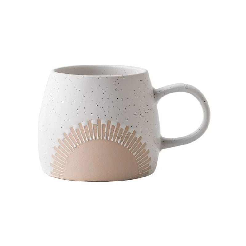 A speckled ceramic mug with an embossed sunburst design in neutral tones, featuring a curved handle and a modern, minimalist aesthetic.