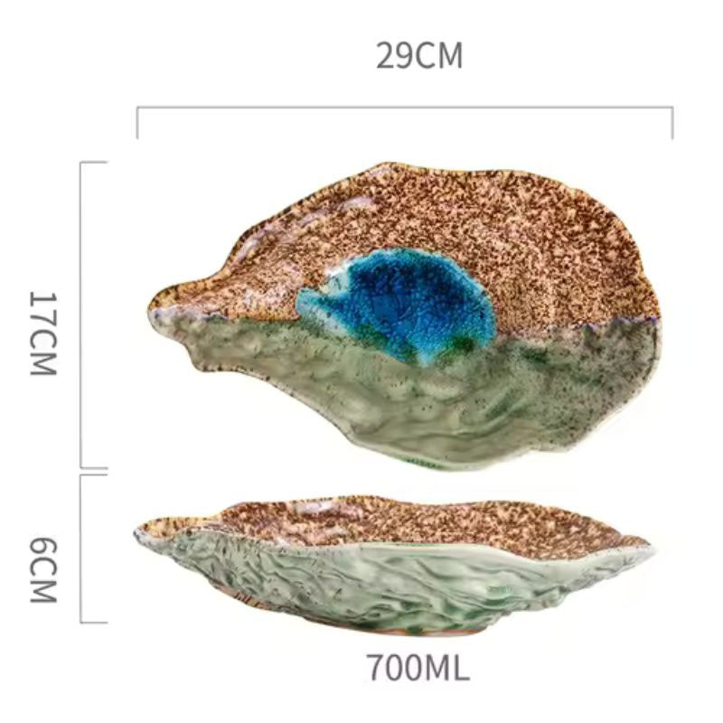 A ceramic spoon rest with a unique, organic shape and speckled brown and green glaze, shown with dimensions: 29cm length, 17cm width, 6cm height, and a capacity of 700ml.