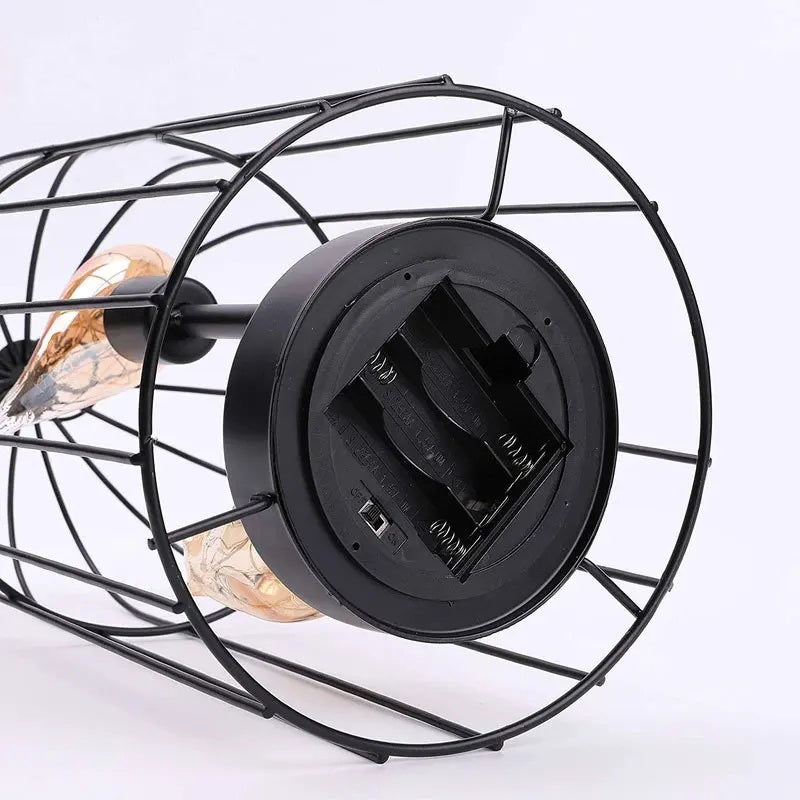 Black metal wall light fixture with glass shades on a white background