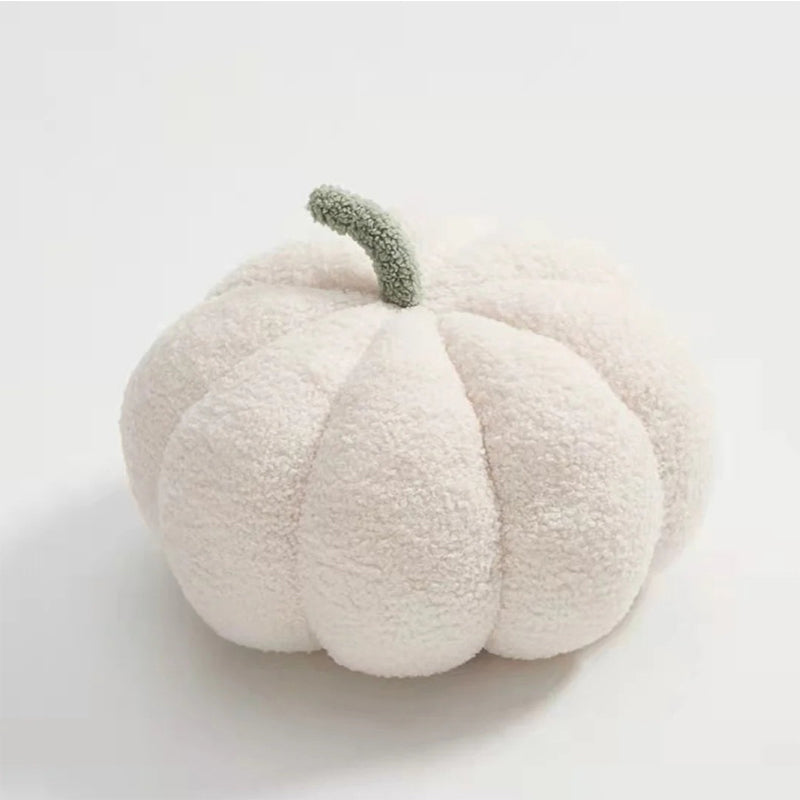 A fuzzy, white pumpkin-shaped pillow with a light green stem.