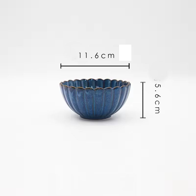 A blue ceramic bowl with a scalloped rim and vertical ridges.