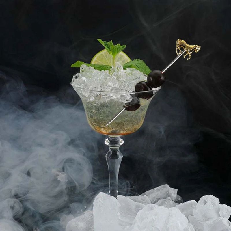 A cocktail in a stemmed glass with ice, cherries, lime, mint, and a horse-shaped cocktail pick, surrounded by smoke and ice.