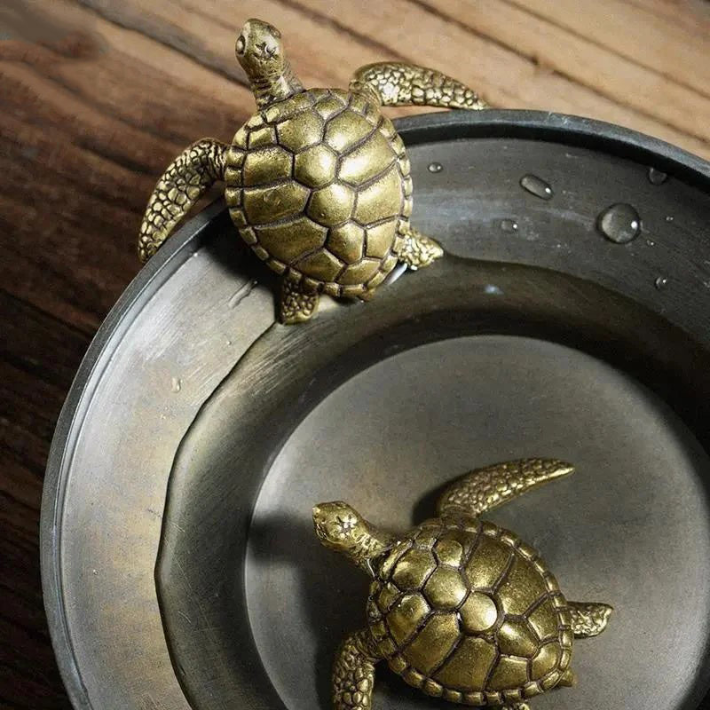 Bronze turtle figurines on a metal surface