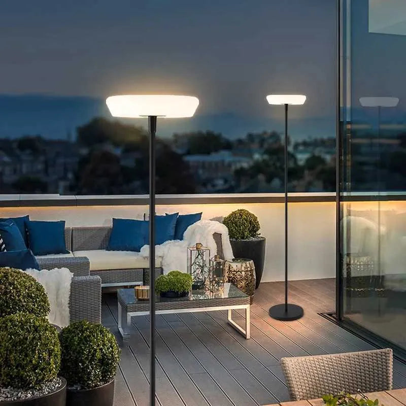 Outdoor patio with modern furniture, floor lamps, and a cityscape view.