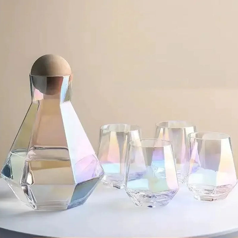 Iridescent glass pitcher and four matching faceted glasses on a light surface. The glass displays rainbow-like colors.