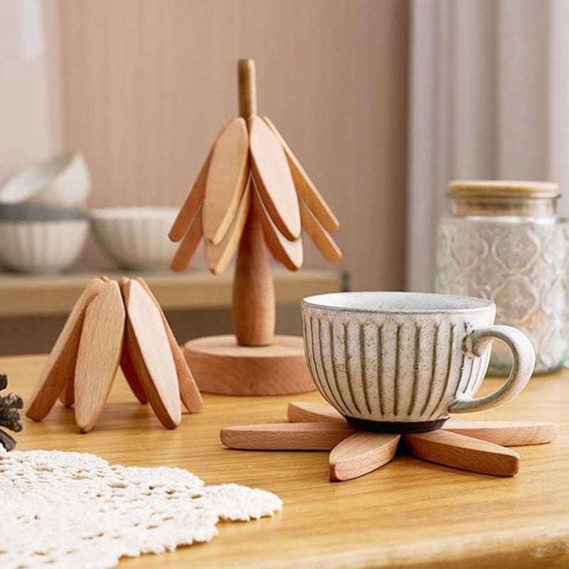 The image shows three wooden trivets: two tree-shaped and one starburst-shaped, with a mug on the starburst trivet.
