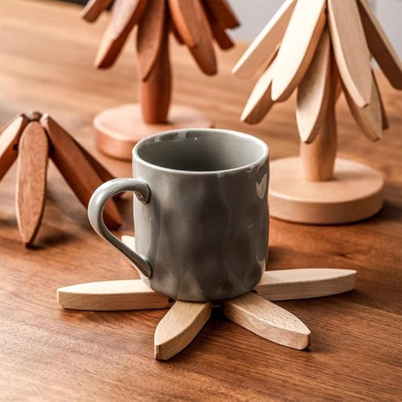 Two tree-shaped wooden trivets, one light and one dark, and a starburst-shaped trivet with a mug on it.
