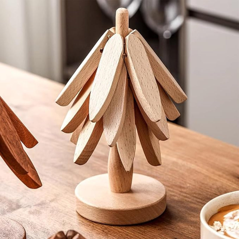 A light-colored wooden trivet, shaped like a stylized tree, stands on a wooden surface.