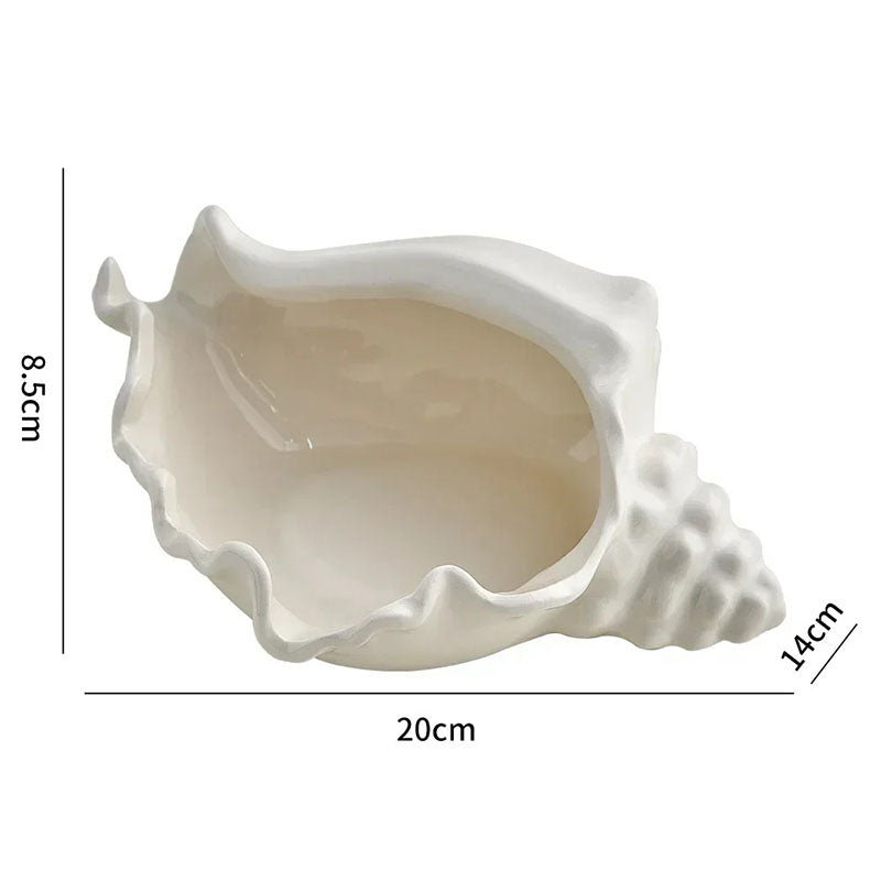 A white ceramic shell-shaped bowl with a glossy finish, designed to resemble a conch shell. The bowl has an open interior and wavy, textured edges. Dimensions are marked as 20 cm in length, 14 cm in width, and 8.5 cm in height.