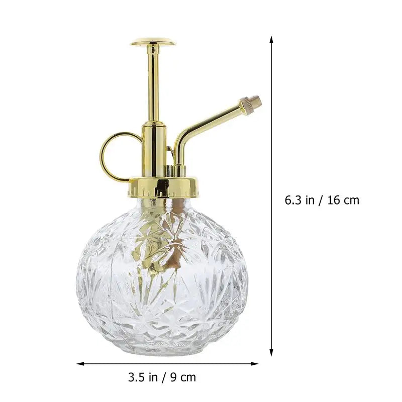 A clear glass plant mister with a gold pump is displayed with dimension measurements: 6.3 inches (16 cm) in height and 3.5 inches (9 cm) in width.