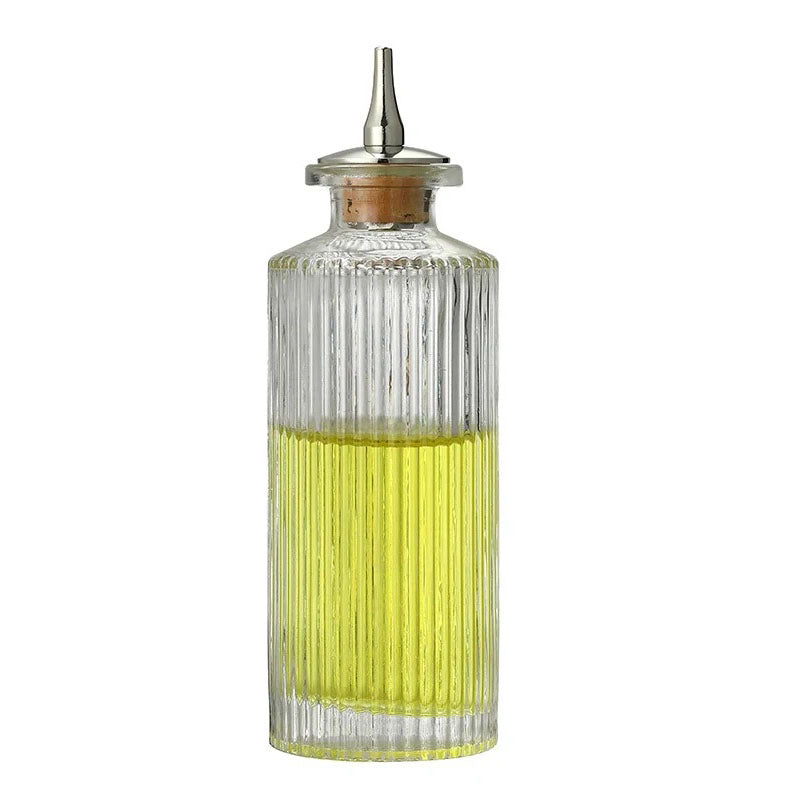 This bottle has a straight, cylindrical shape with vertical ribbing from top to bottom. The classic ridged texture enhances grip and aesthetics. The transparent glass allows the vibrant yellow oil inside to stand out. It features a cork stopper and a metal spout for controlled pouring.