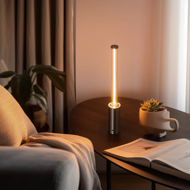 Modern table lamp on a side table with a book and plant in a cozy room setting.