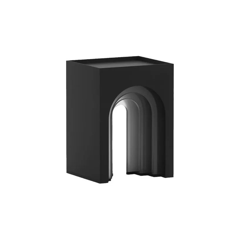 A modern, dark gray solar arch lantern illuminates an outdoor lounge area.