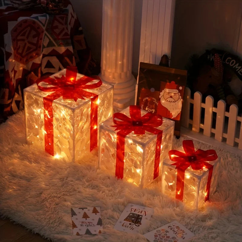 Three illuminated gift boxes with red bows on a white fluffy rug, with Christmas cards nearby.