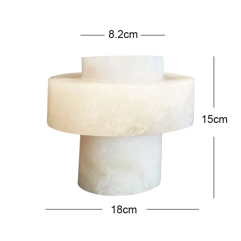 A modern alabaster vase with a unique geometric design, featuring a cylindrical base and a wider circular midsection. The vase has a smooth, semi-translucent white surface with subtle natural variations. Dimensions are labeled: 8.2 cm for the top opening, 18 cm for the widest section, and 15 cm in height.