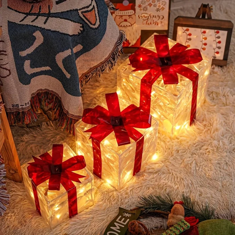 Three luminous gift boxes with red bows on a fluffy rug, under a patterned blanket.