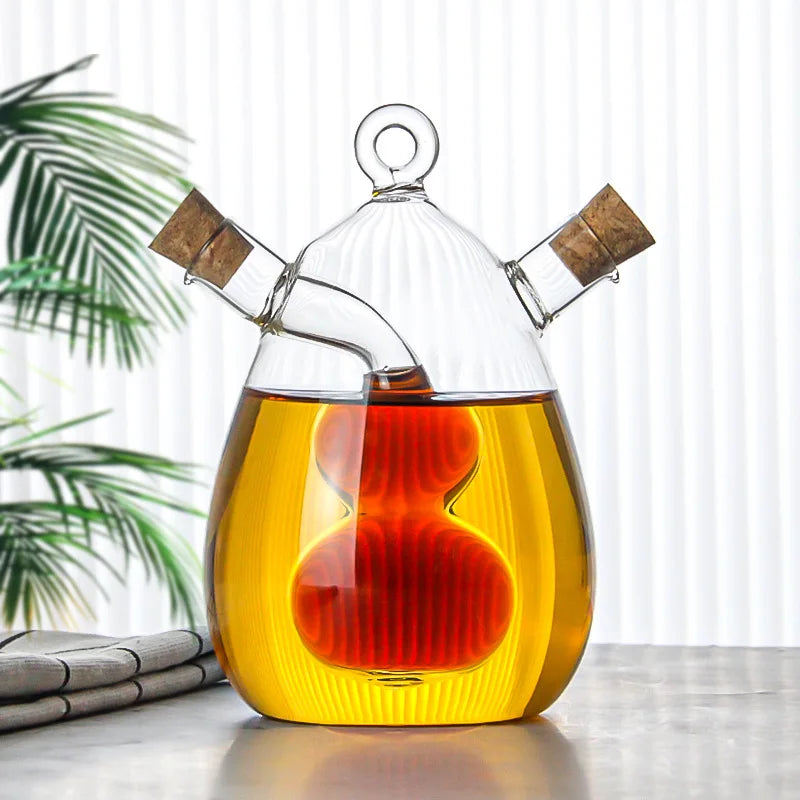 Glass oil and vinegar dispenser with a plant in the background