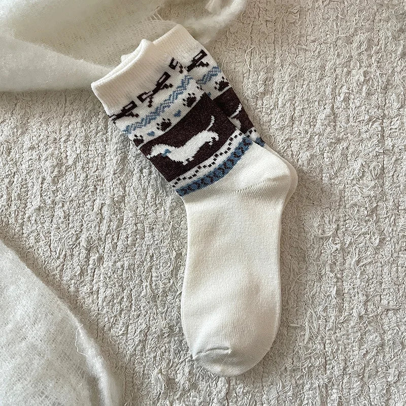 White sock with black and blue pattern on a textured beige surface