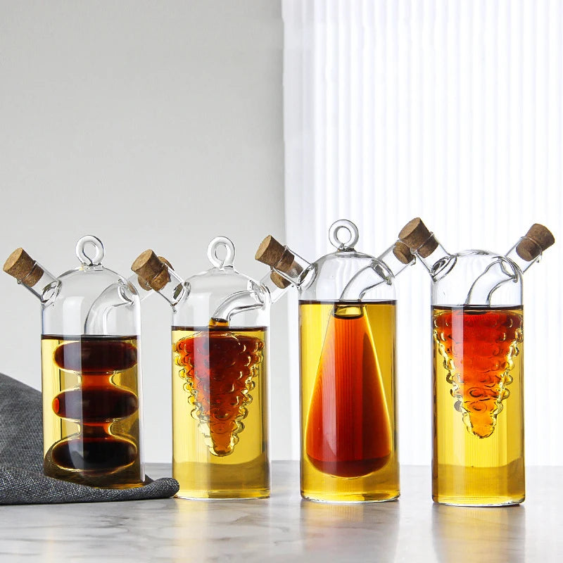 Set of four glass bottles with cork stoppers containing different liquids on a light surface.