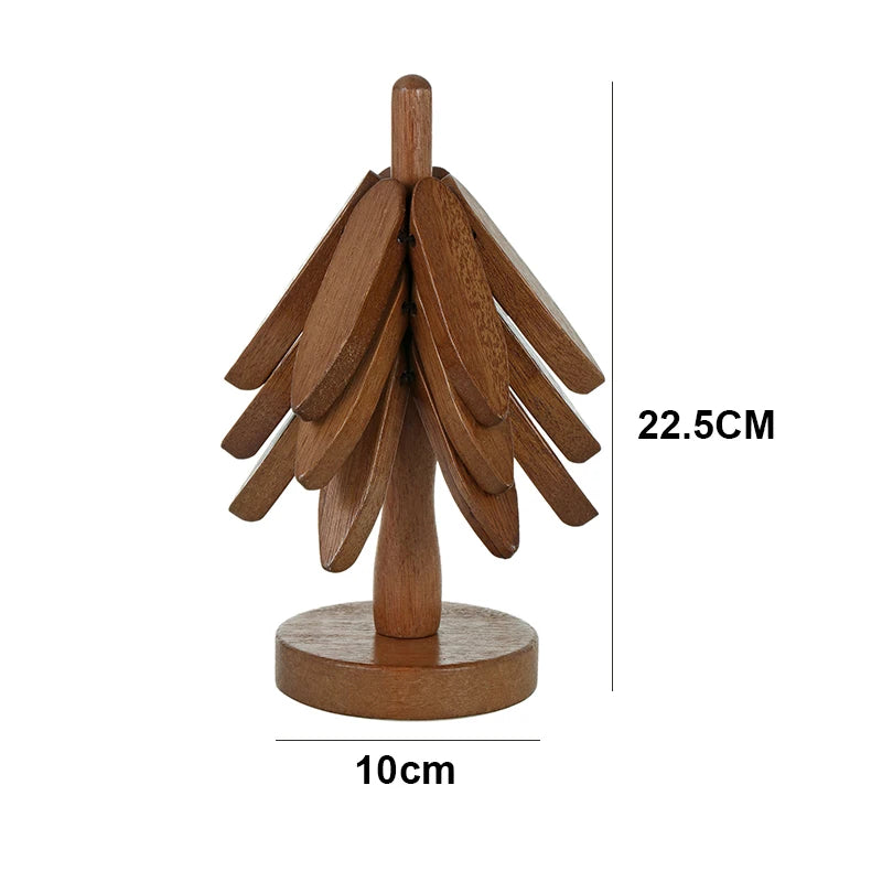 A dark wooden trivet, shaped like a stylized tree, stands upright. Dimensions indicate it's 22.5 cm tall and has a 10 cm base diameter.