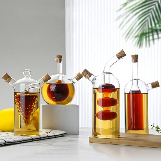 Set of glass oil and vinegar bottles with wooden caps on a white surface.