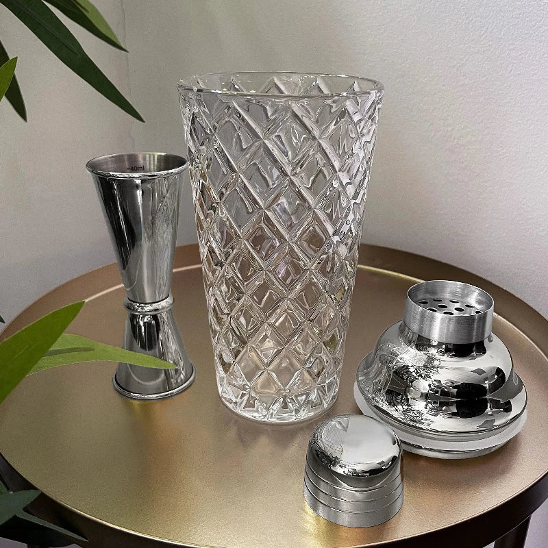 Cocktail shaker made of clear glass with a shiny silver top for easy mixing and pouring.