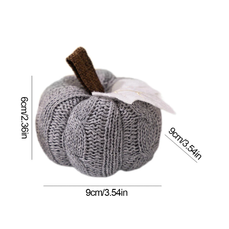 A gray knitted pumpkin with a brown stem and a white leaf is shown with dimensions of 9cm (3.54in) in width and depth, and 6cm (2.36in) in height, on a white background.
