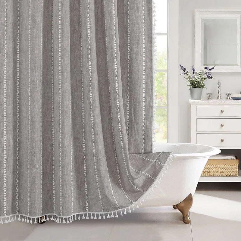 Gray striped curtain with tassels in a bathroom setting