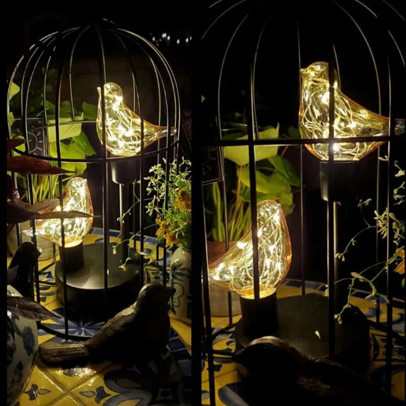 Decorative birdcage with illuminated birds and plants on a patterned floor.