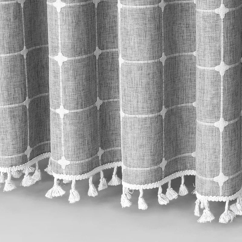 Textured fabric with geometric pattern and tassels on a light gray background