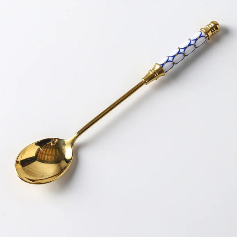 Gold spoon with decorative handle on a white background