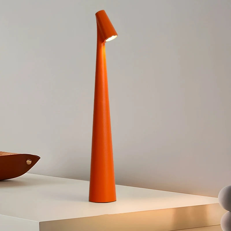 A bright orange, tall and slender lamp with a unique, modern design, standing on a white surface.