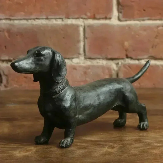 Black dachshund figurine on a wooden surface.