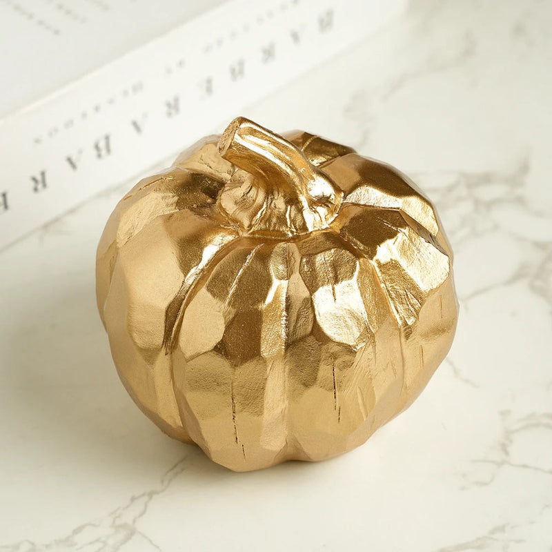A small, faceted golden pumpkin decoration.