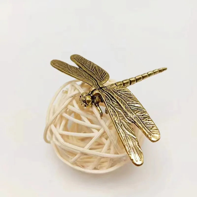 Gold dragonfly-shaped object on a white background