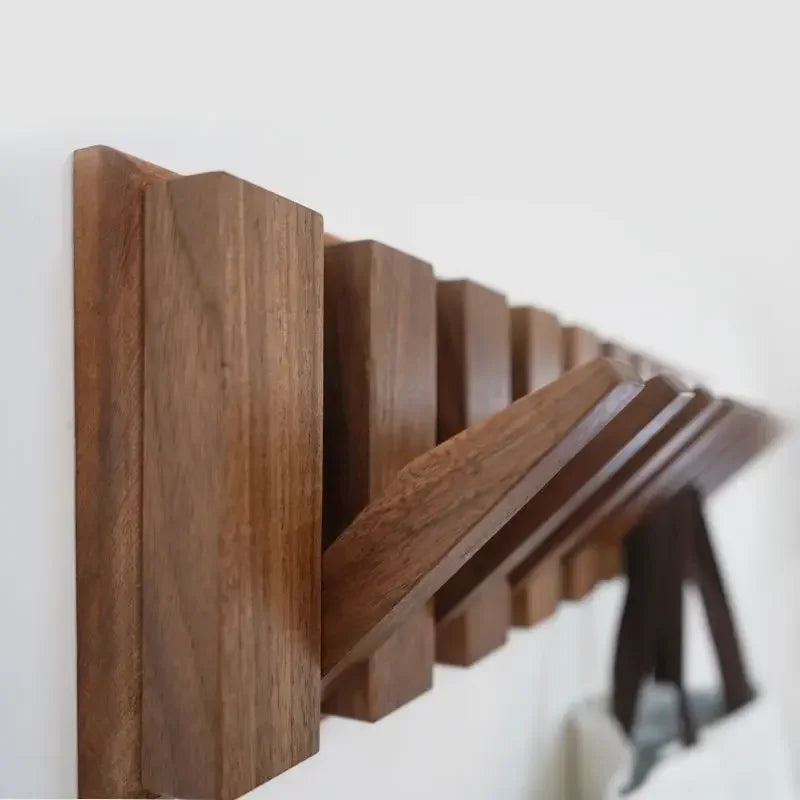 Wooden wall shelf with hooks on a white background