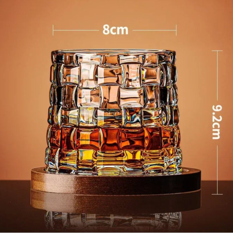 A textured glass with a basket-weave pattern and amber liquid sits on a wooden coaster, with its dimensions noted.