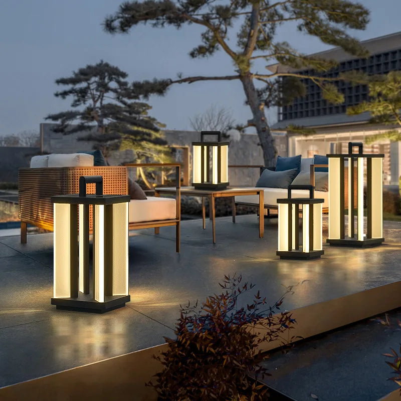 Four illuminated "Villa Solar Lamps" of varying sizes light up a modern outdoor patio with lounge furniture at dusk or night.