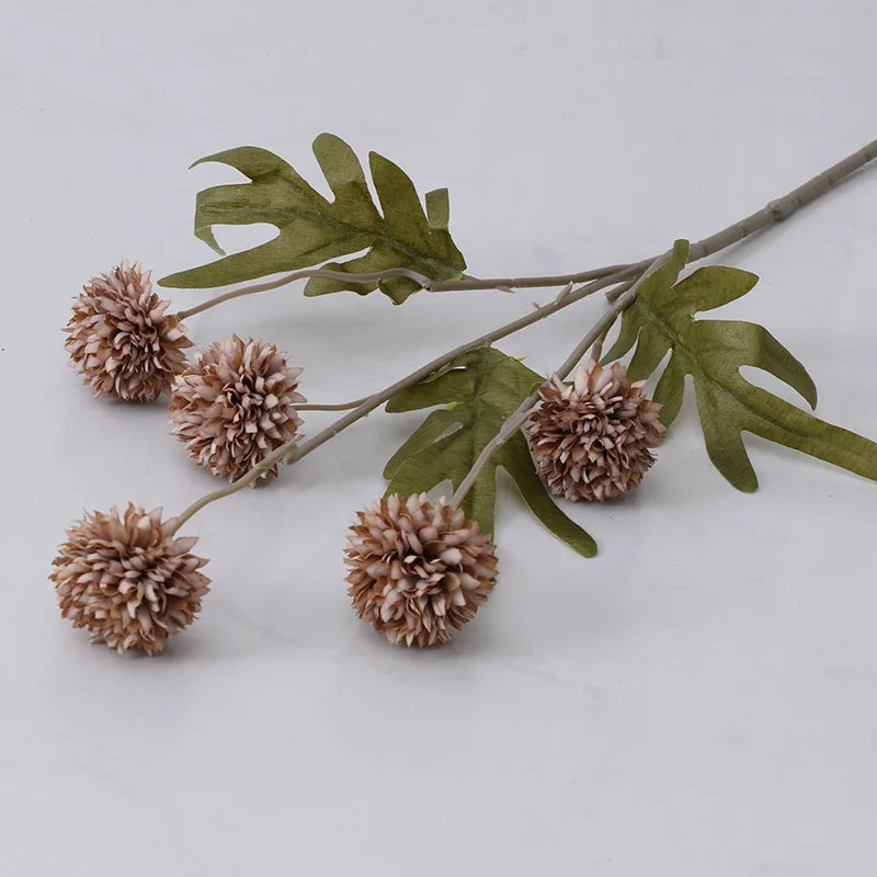 Brownish-pink faux floral stem with five spherical blooms and green leaves.