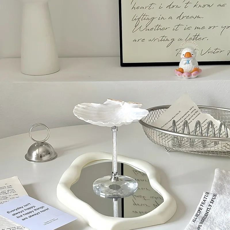 Heart-shaped mirror on a white surface with decorative items