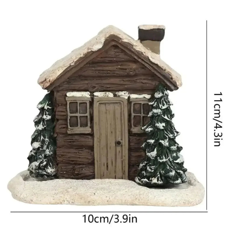 Miniature cabin with snow-covered roof and trees on a white background