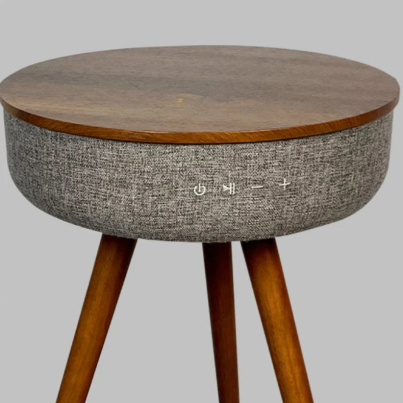 A close-up studio shot of a wooden end table with a built-in Bluetooth speaker, showing the control buttons.