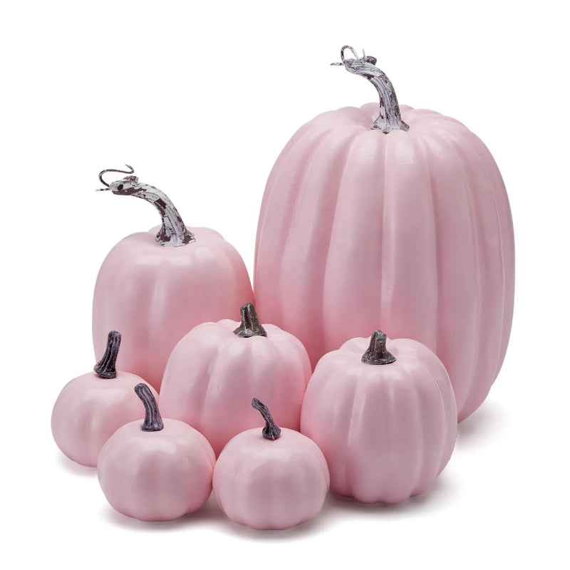 A cluster of pink decorative pumpkins of various sizes with grey stems.