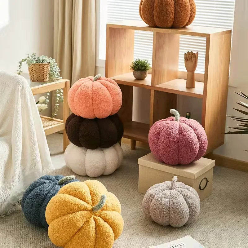 A cozy room features an assortment of pumpkin-shaped pillows in various colors, with some stacked, some on the floor, and one on a wooden shelf.