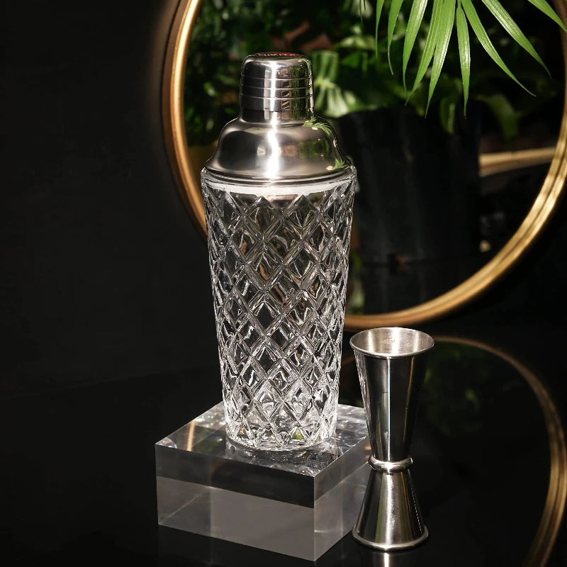 Transparent glass cocktail shaker with a sleek design, ideal for home bars.