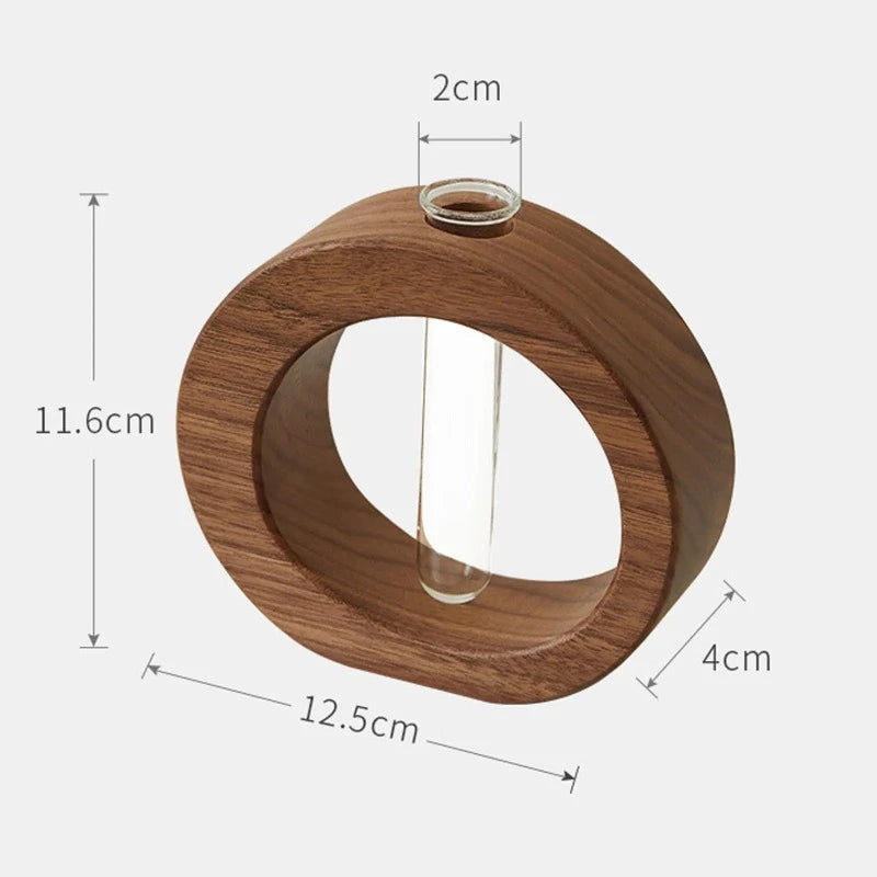 A dark wooden circular vase, measuring 12.5 cm wide and 11.6 cm tall, holds a transparent glass test tube. The opening of the test tube is 2 cm wide, and the wooden base of the vase is 4 cm thick.