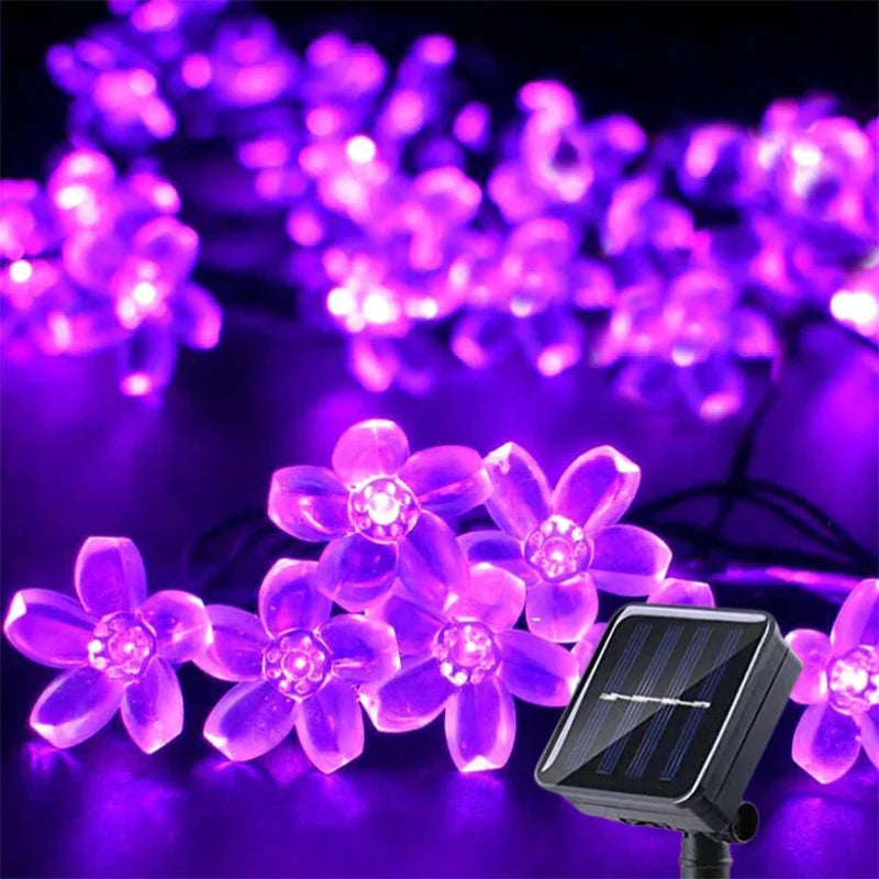 Solar-powered purple LED flower string lights and solar panel.